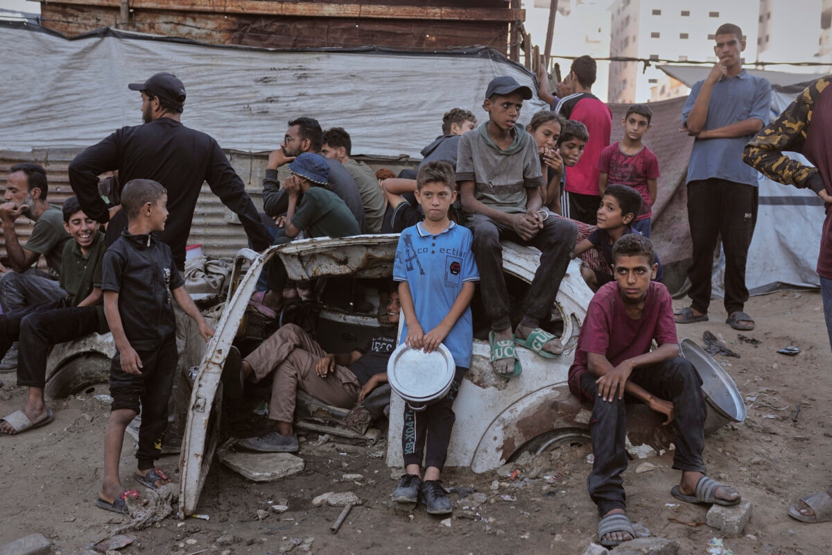 Palestinians wait for donated food at a community kitchen in Gaza City, in the northern Gaza Strip, July 14, 2025. (AP Photo/Jehad Alshrafi)